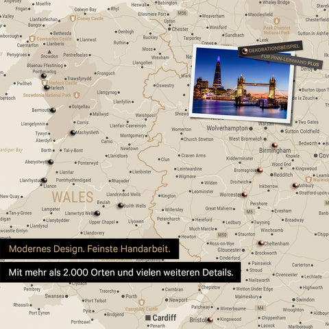 Detail of a gold-colored map of Wales and England with pins marking visited destinations